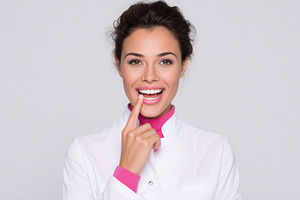 Smiling female dentist points to her, a Health & Medical Photo by MistyDay
