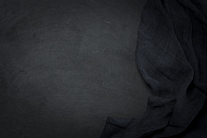 Folded black gauze kitchen napkin on black table, top view, a Background Photo by ndanko