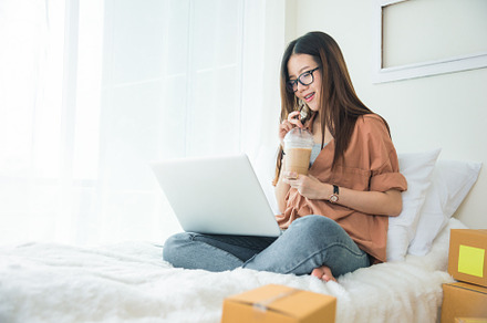 Beauty Asian woman using laptop and drinking coffee on bed. Busi, a Person Photo by Ministocker