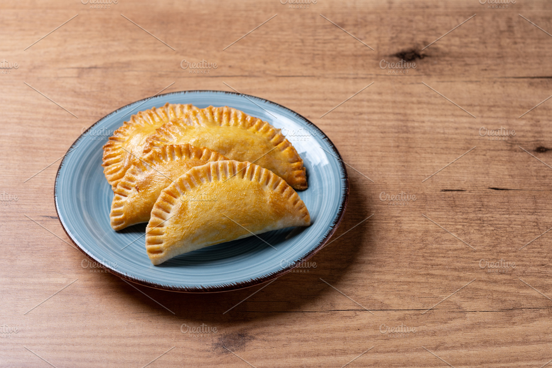 Golden baked empanadas served on a plate, a Food & Drink Photo by etorres69