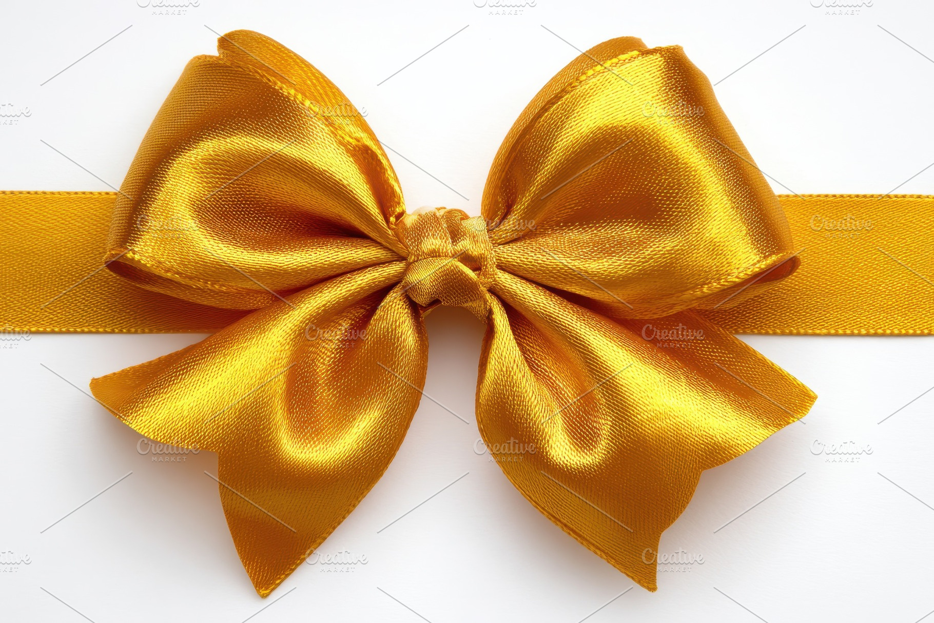 Golden satin ribbon bow elegant gift, a Photo by Pixeness Studio