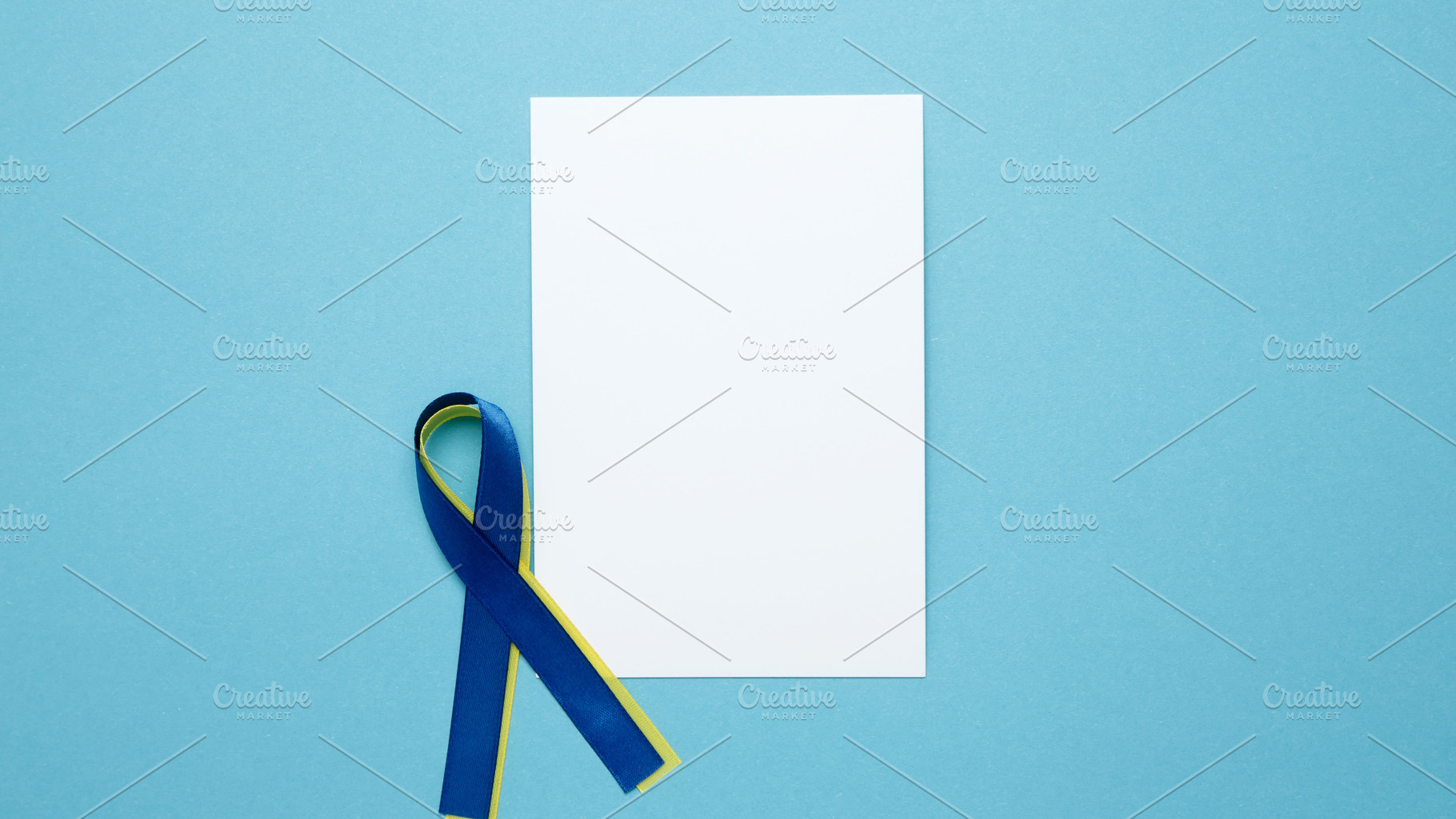 White notebook mockup. A yellow and blue awareness ribbon, symbolizing World Do, a Photo by matucha
