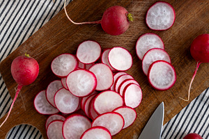 Raw Red Radish Slices on a Cutting Board, top view., a Food & Drink Photo by LiudmylaChuhunova