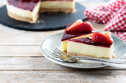 Slice of cheesecake with strawberries on wooden table, a Food & Drink Photo by etorres69
