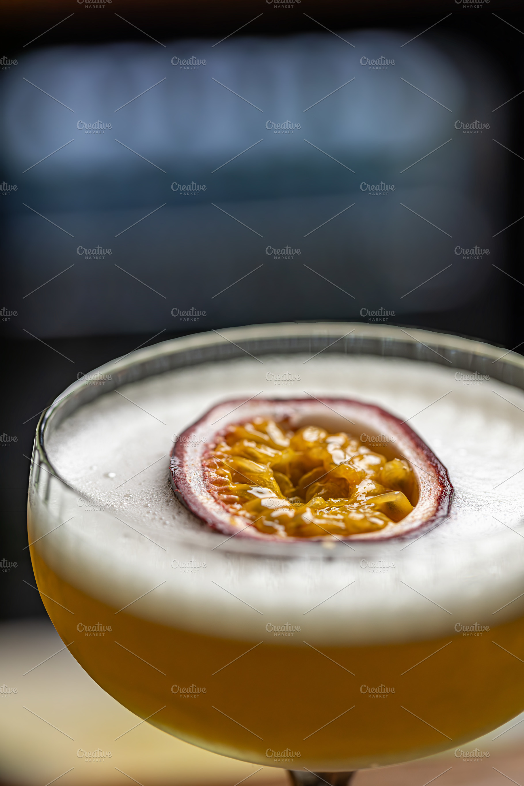 Cocktail with foam, and passion fruit garnish, a Photo by Grafvision photography
