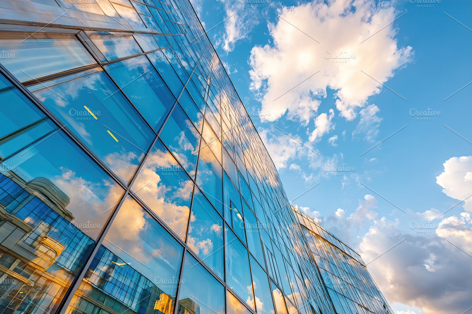 Building facade reflecting clouds under a vibrant blue sky during daytime, an Architecture Photo by AlyaAnd