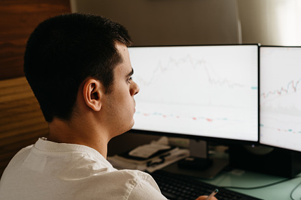 Successful young trader in casual wear working with charts and market reports a, a Person Photo by Architect´s eye