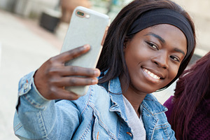 Young african american woman taking a selfie with smartphone, an Abstract Photo by Antonio Gravante Market