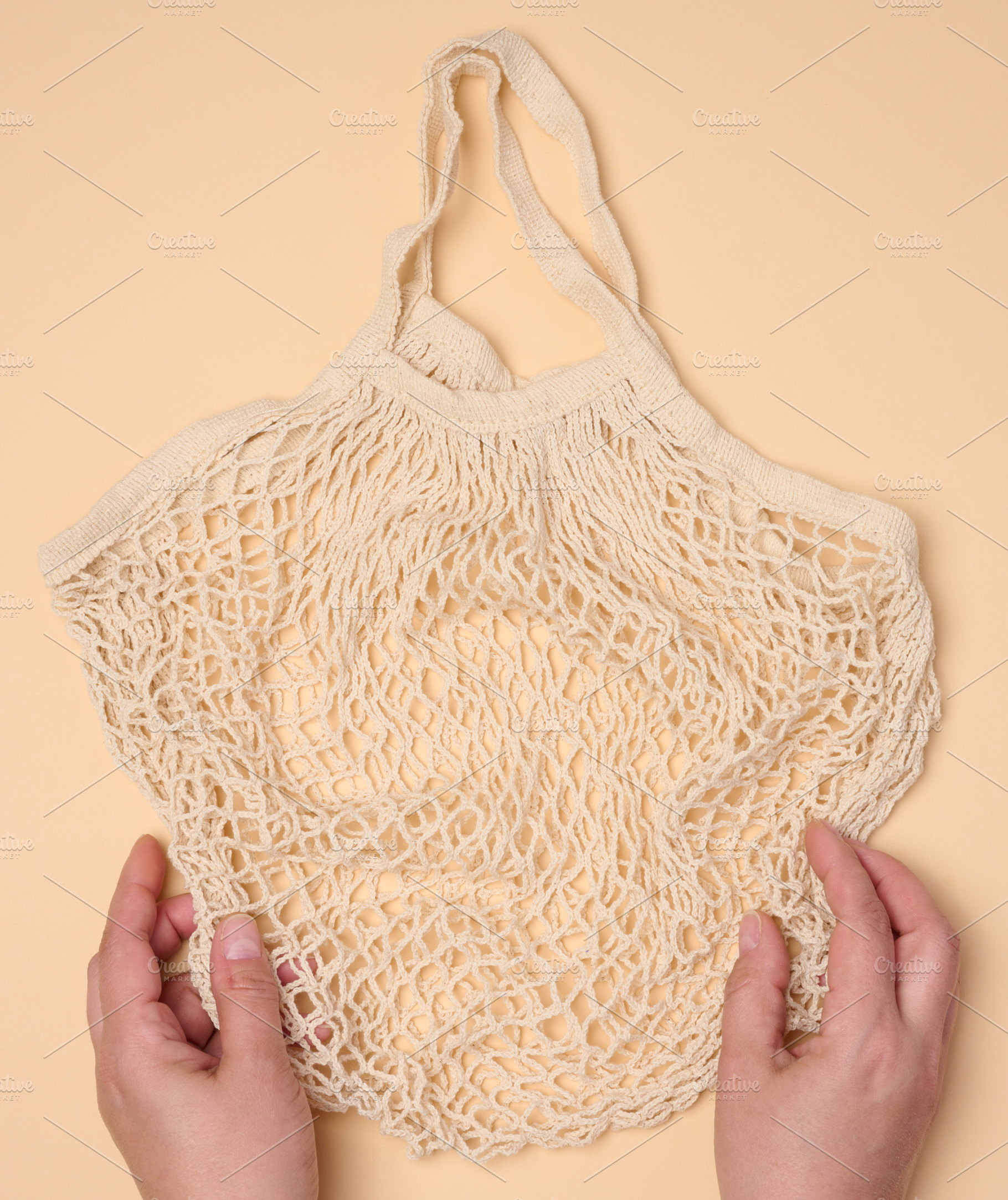 Empty reusable cotton mesh bag in female hands, a Person Photo by ndanko