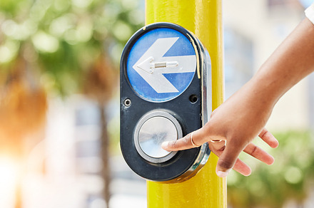 Crosswalk, arrow and button with hand of woman in city for traffic light, intersection and safety. Travel, sign and stop with person at pedestrian crossing in street for press, transport and warning, a Photo by Peopleimages.com