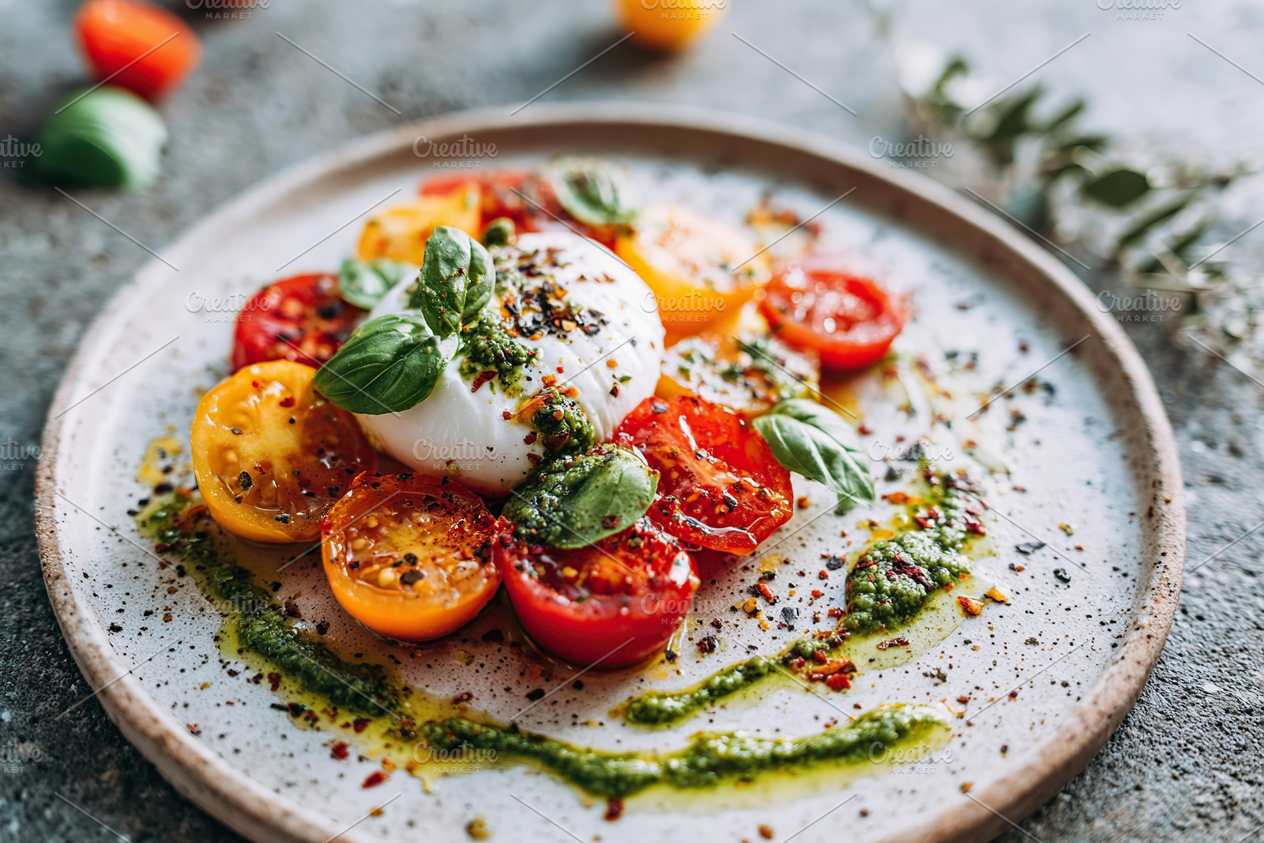 Fresh salad with heirloom tomatoes topped with pesto and basil on a stylish pla, a Food & Drink Photo by AlyaAnd