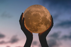 Hands holding up moon stock photo containing sky and clouds