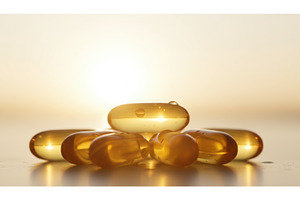 Golden supplement capsules glow in, a Health & Medical Photo by Igor Tichonow