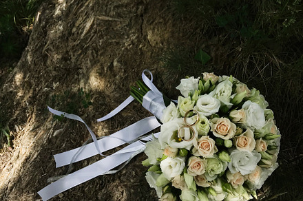 Beautiful bridal bouquet with rings on natural stone surface, a Photo by AS photostudio