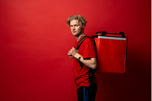 Young courier man in red t-shirt, a Person Photo by volodymyrshtun13795