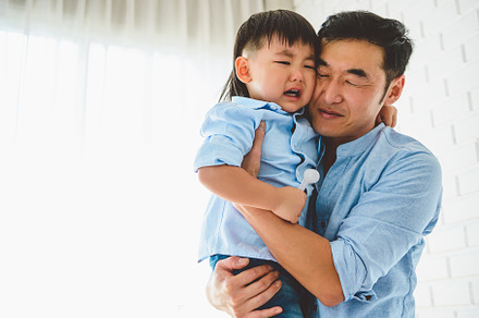 Asian Japanese father carrying and consoling his crying son in b, a Person Photo by Ministocker