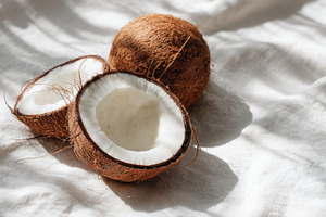 Coconuts on a soft white fabric, a Photo by Beautiful things