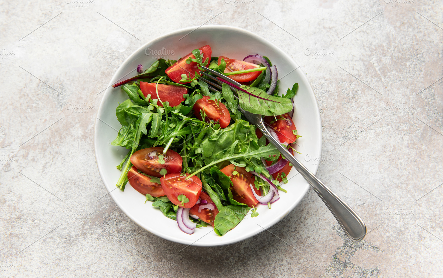 Fresh green salad with tomatoes and red onion, a Food & Drink Photo by Olena Rudo