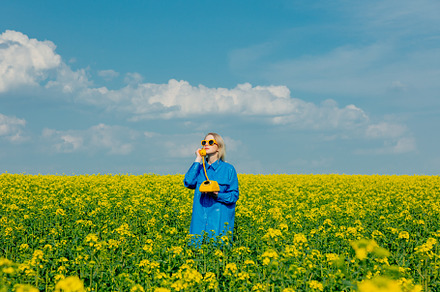 Ukrainian woman with yellow telephone in rapeseed field in sprin, a Person Photo by Masson Simon