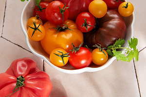 Fresh organic heirloom tomatoes in white bowl, a Food & Drink Photo by Olena Rudo