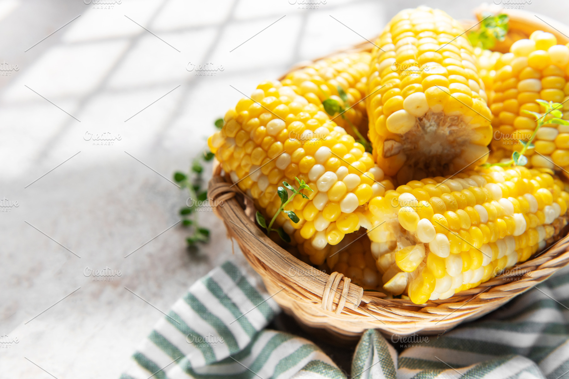 Fresh corn cobs in basket with morning light, a Food & Drink Photo by Olena Rudo