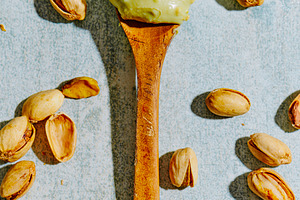 a scoop of pistachio cream on a wooden spoon, a Photo by Nito