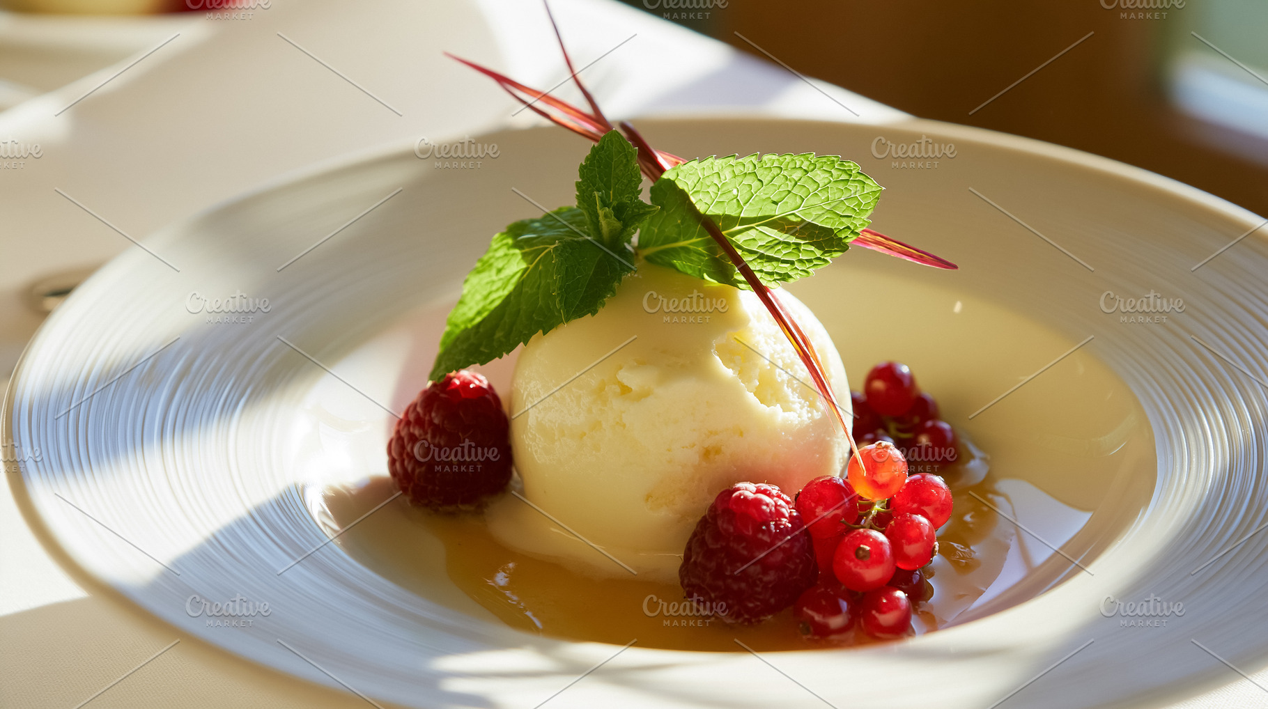 Creamy vanilla ice cream scoop topped with fresh red berries and mint, drizzled, a Photo by Studio ANNA