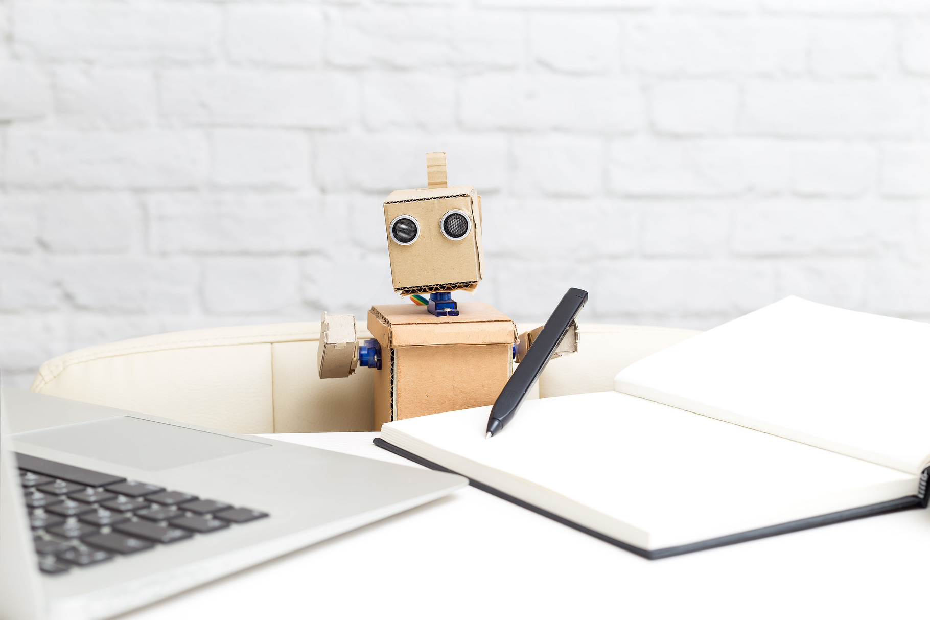 The robot holds a pen in its hand., a Technology Photo by Nastassia