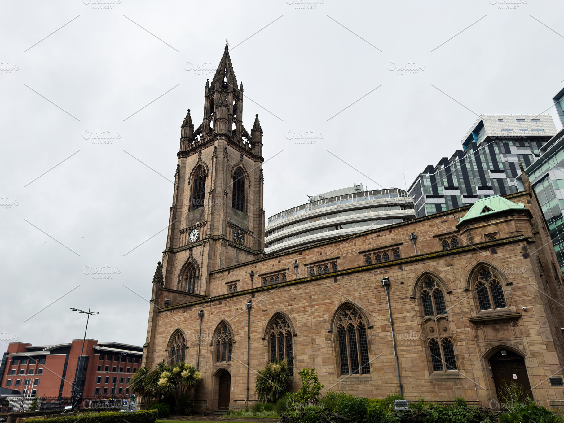 Historic Gothic church with clock tower and modern city building, a Photo by AS photostudio