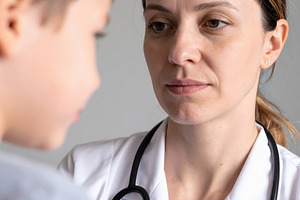 Woman doctor listening carefully to child during consultation, a Person Photo by GoodGoods