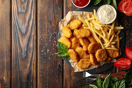 Composition with chicken nuggets, sauces and potato on wooden ba, a Food & Drink Photo by AtlasStudio