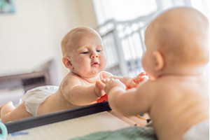 Baby lying on play mat learning to, a Person Photo by Elizaveta Galitskaya