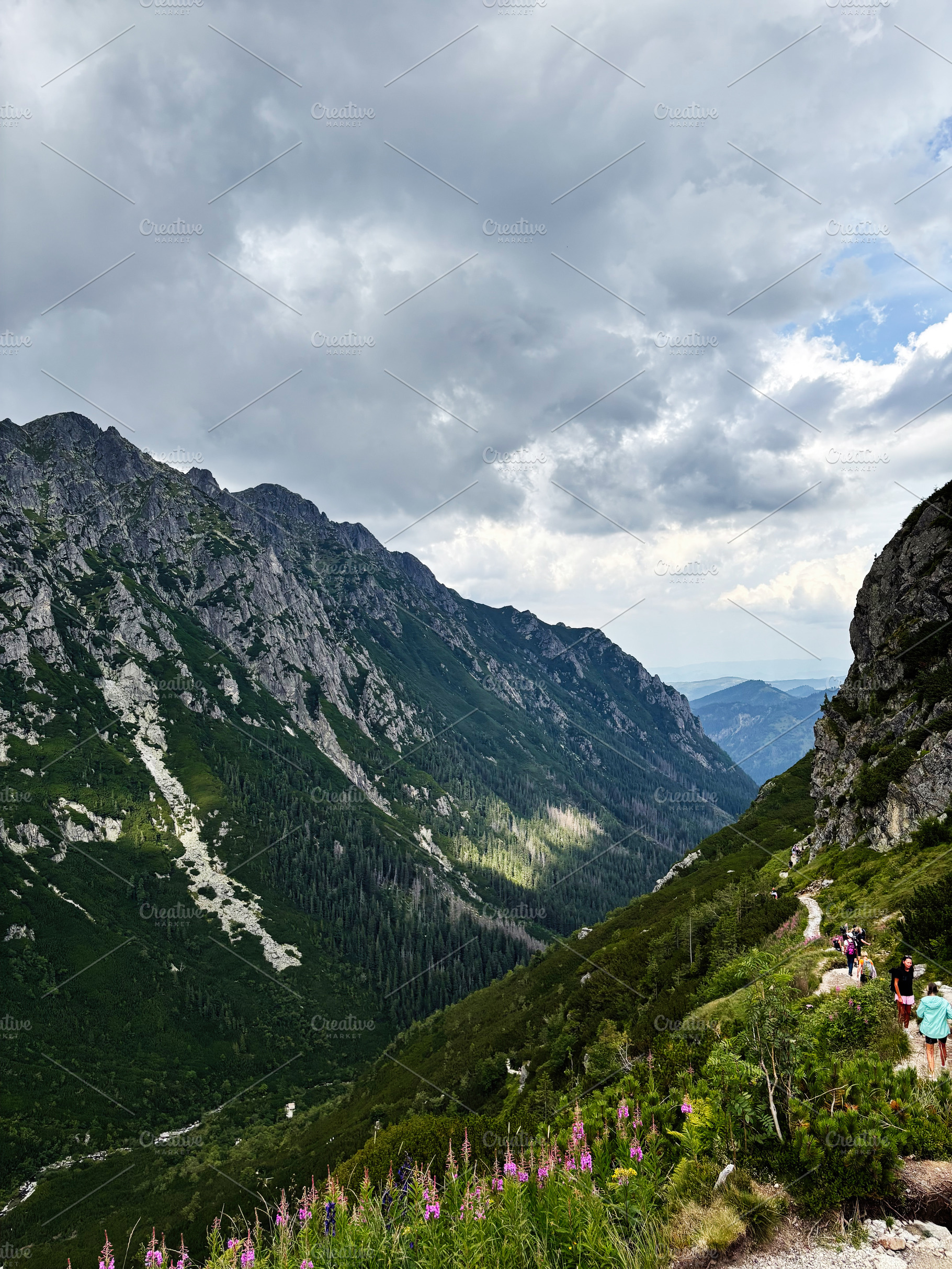 Hikers on a winding mountain trail in Zakopane, Poland under dramatic clouds, a Nature Photo by AS photostudio