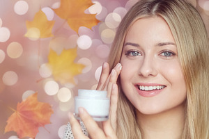 Young woman applying face cream, moisturizing skin for autumn be, a Person Photo by Studio ANNA