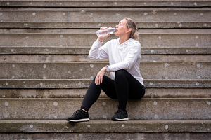 Woman Drinking Water After Workout While Sitting on Outdoor Stairs, a Person Photo by etorres69