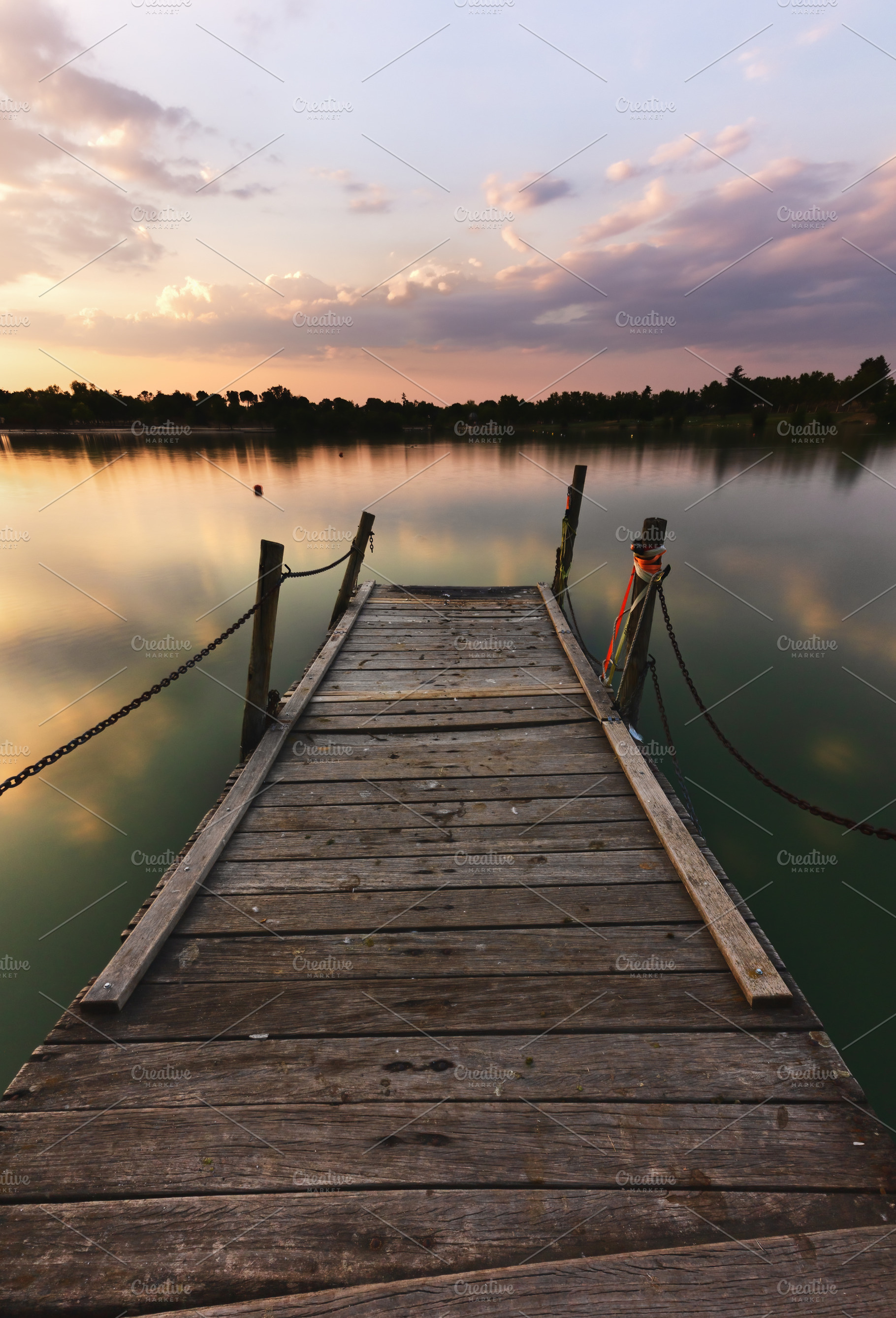 Wooden Pier at Sunset on a Serene La, a Nature Photo by Perpis