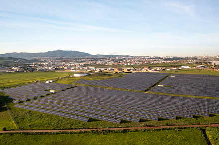 Solar energy farm captures sunlight in rural setting with mountains in the back