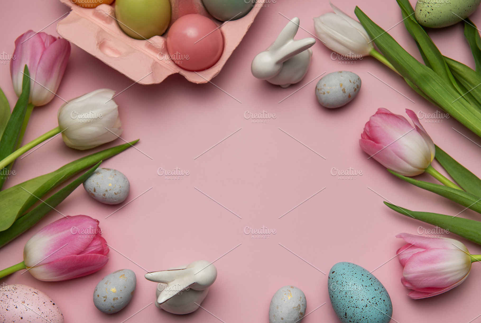 Easter eggs, ceramic bunnies and tulips creating a frame on pink, a Holiday Photo by Olena Rudo