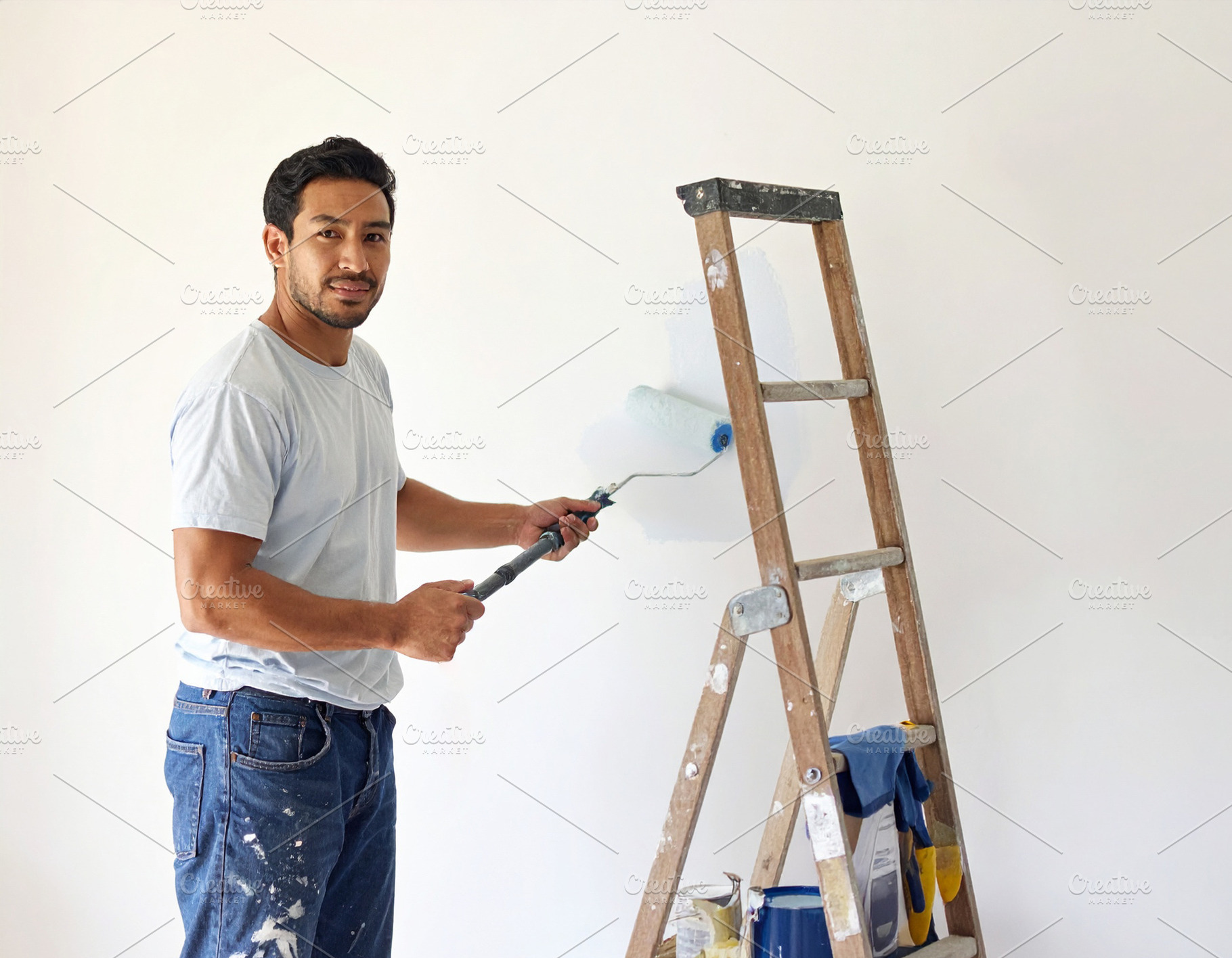 House painter working indoors, painting a wall with a roller, a Person Photo by DanFLCreativo