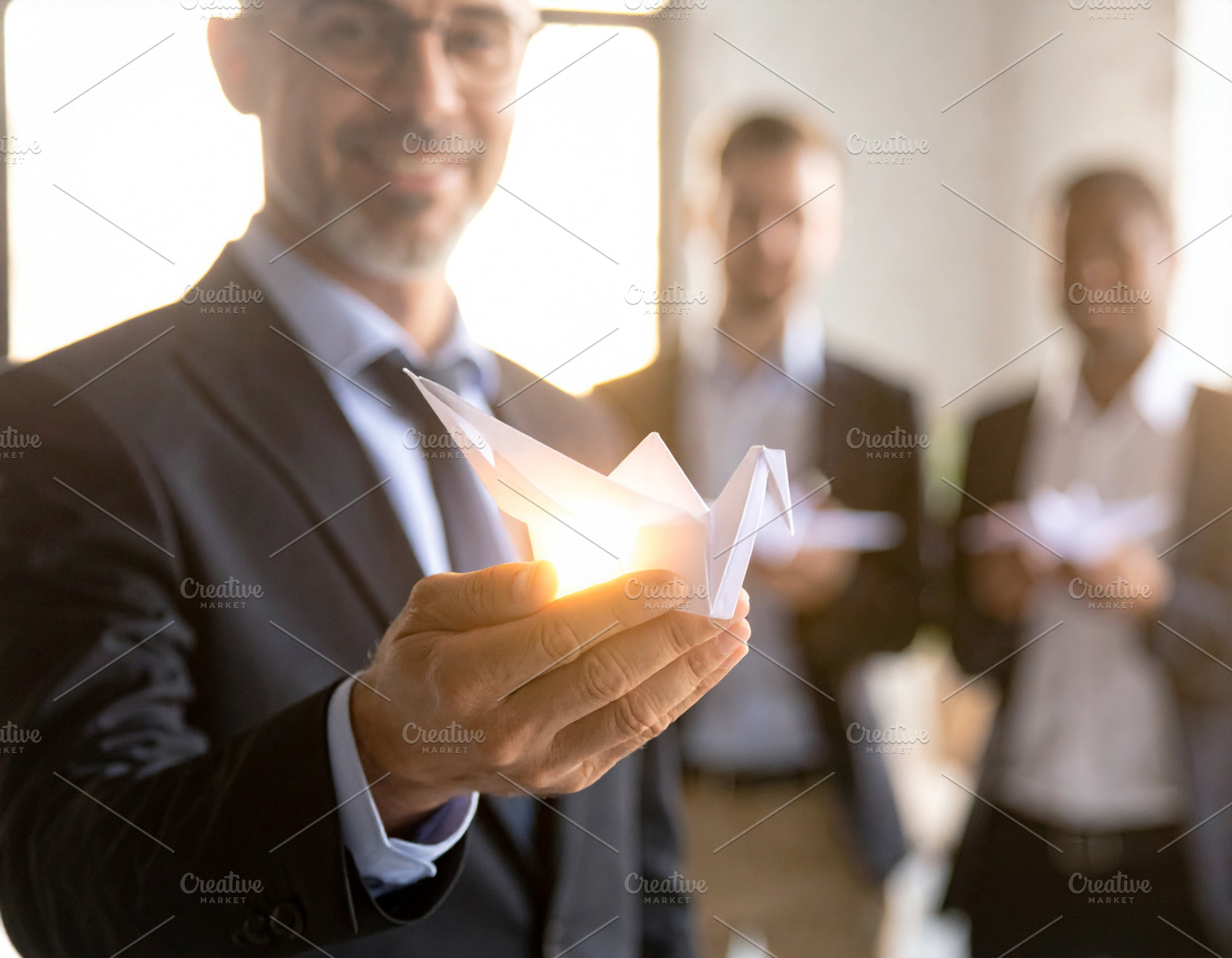 Business leader holding a glowing origami bird close to chest, a Technology Photo by DanFLCreativo