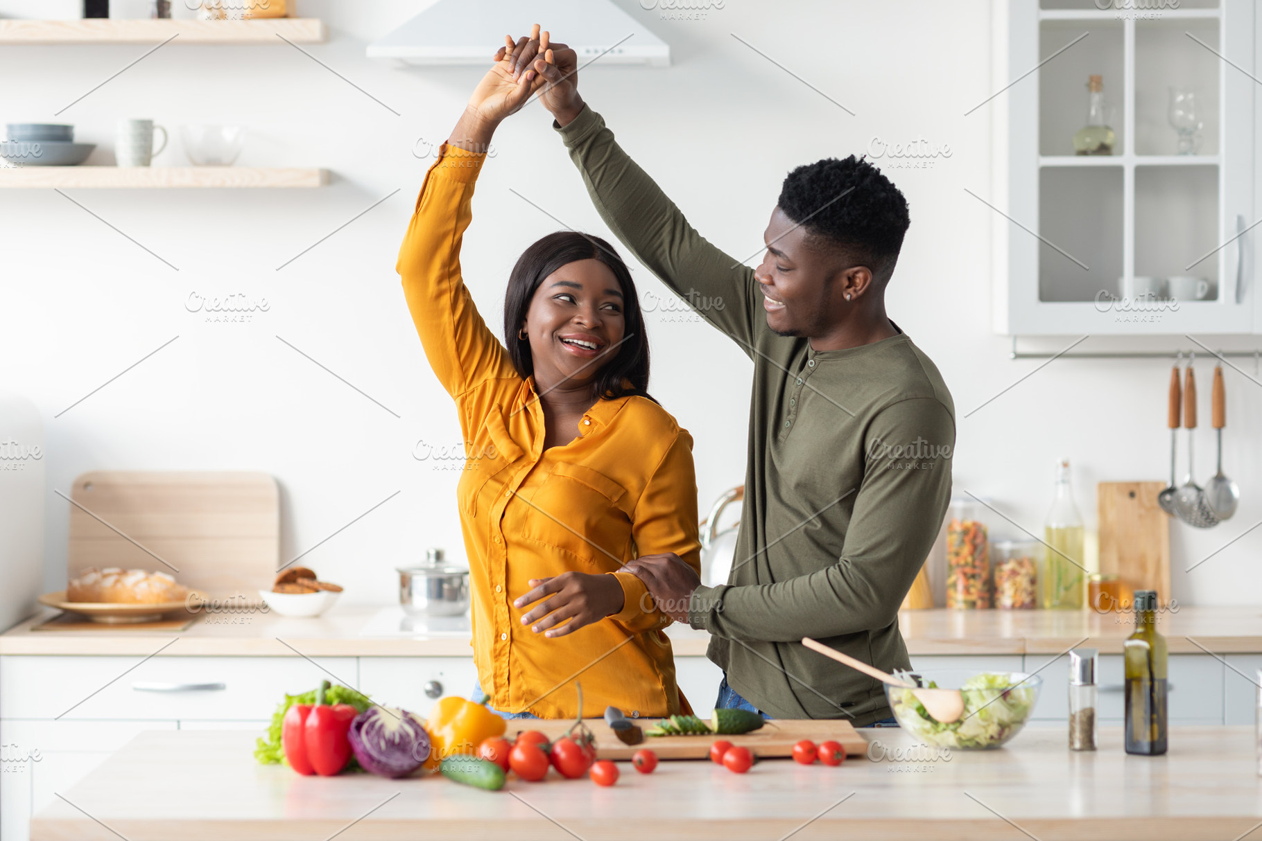Portrait Of Cheerful Black Romantic Couple Dancing In Kitchen While Cooking, a Photo by Prostock-Studio