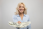 Happy young business lady holding fan of American money, showing banknotes to c, a Photo by Prostock-Studio (Thumbnail 2 of 2)