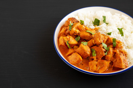 Homemade Easy Indian Butter Chicken with Rice on a Plate on a bl, a Food & Drink Photo by LiudmylaChuhunova