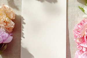 Blank paper card mock up resting on linen fabric with colorful p, a Photo by Studio ANNA