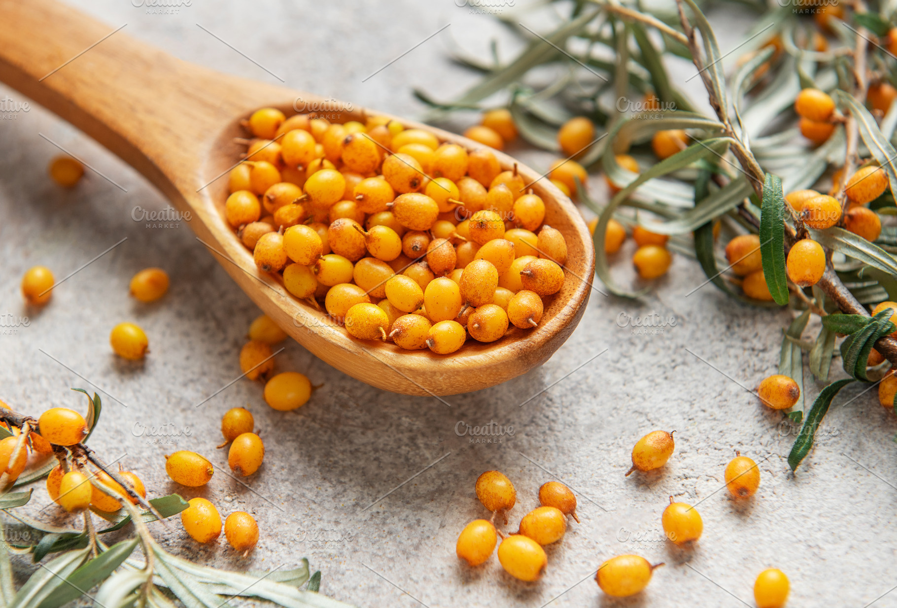 Wooden spoon overflowing with fresh sea buckthorn berries and le, a Food & Drink Photo by Olena Rudo