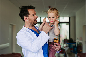 Handsome doctor holding young, a Person Photo by HalfPoint