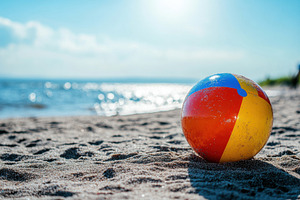 Colorful beach ball resting on sandy, a Photo by Iftikhar Alam
