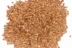 Raw buckwheat grains on isolated background, close up, a Food & Drink Photo by ndanko