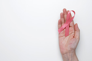 Symbol of breast cancer awareness. Woman hand holding pink ribbon, a Photo by matucha