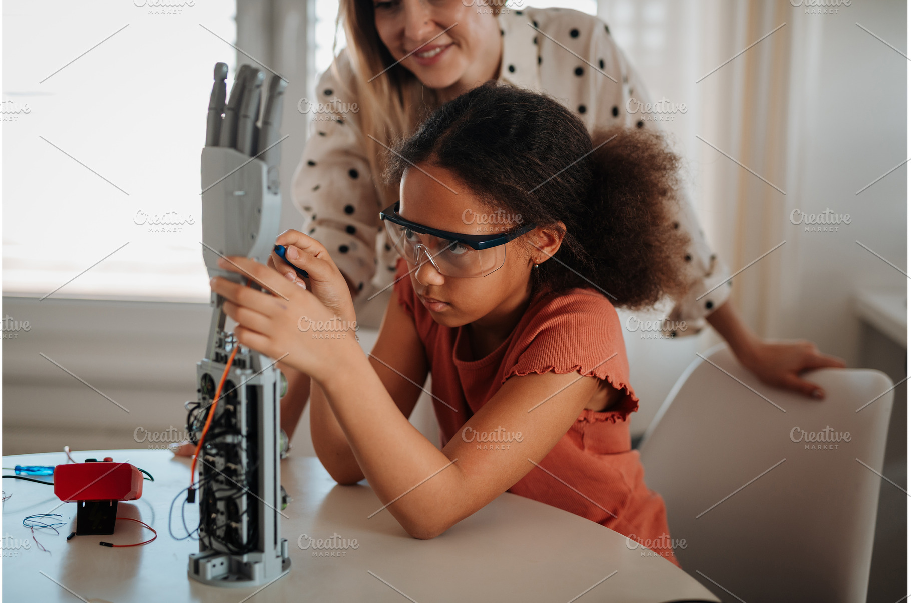 Mom teaching daughter robotics and, a Technology Photo by HalfPoint